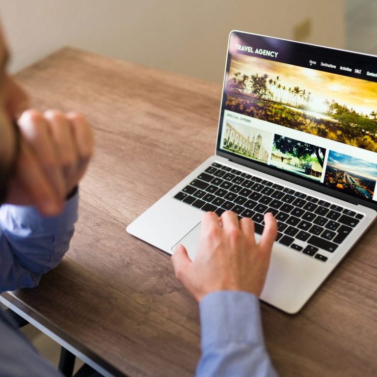 Young man working and reading travel information to book a client vacation. Travel agent booking a flight trip at his office